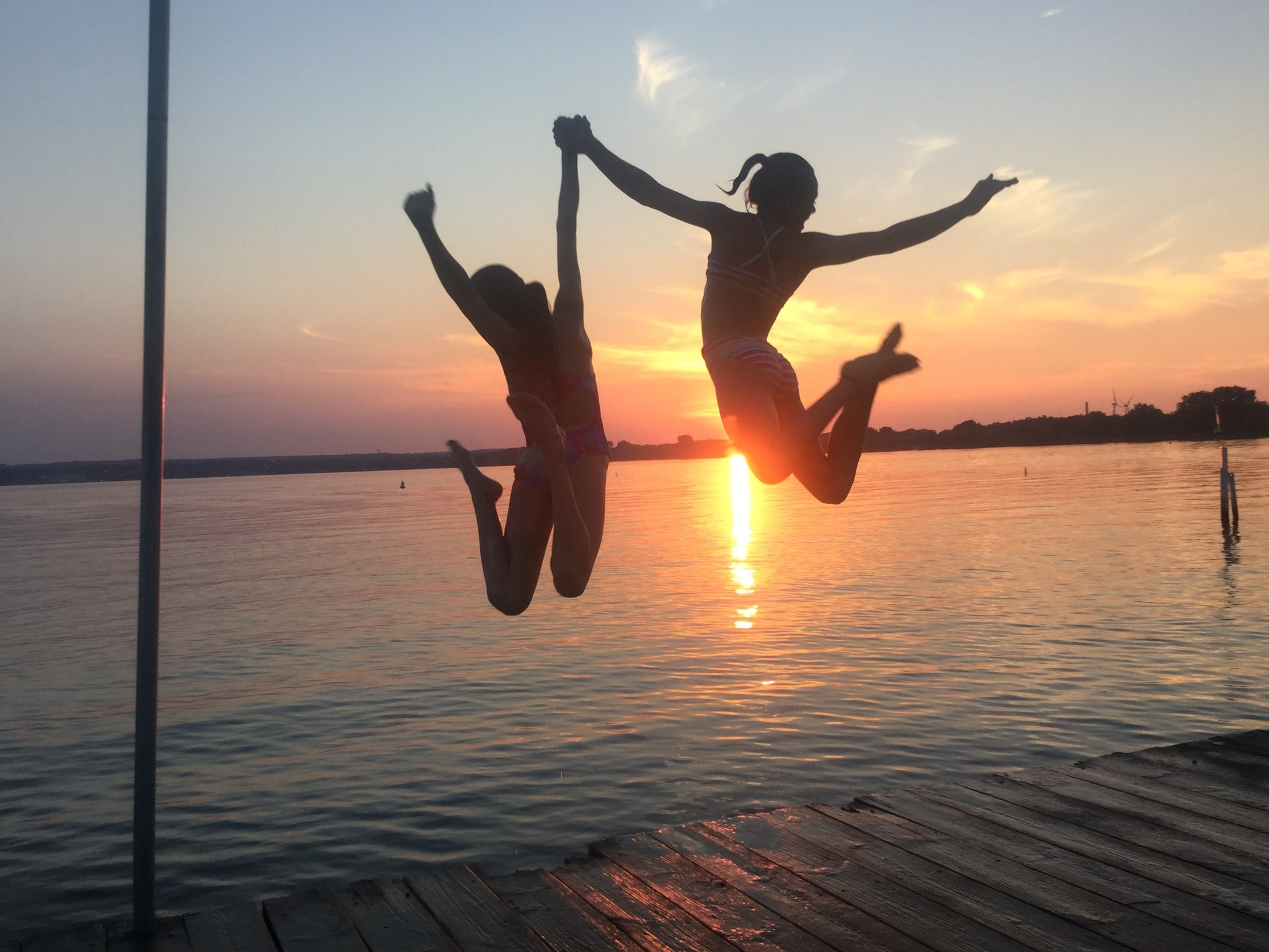 Silhouetted kids jumping at sunset